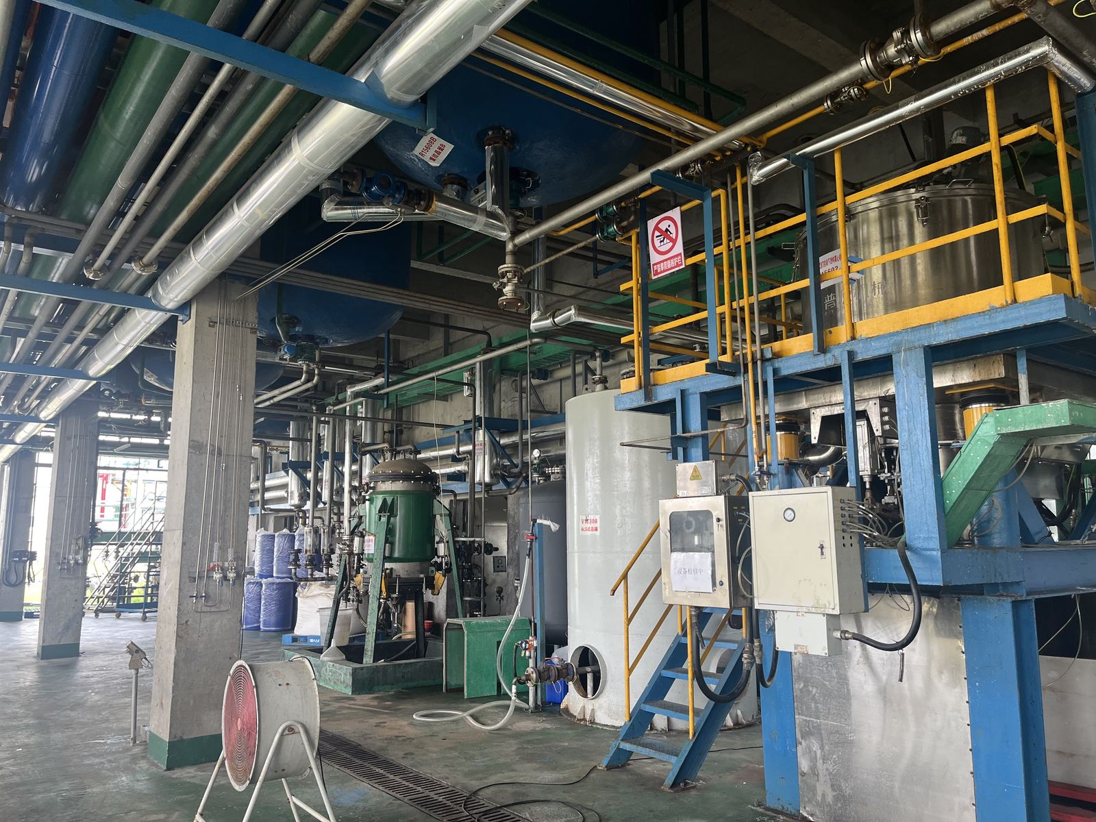 Reactors, pipe racks and process vessels in a production workshop